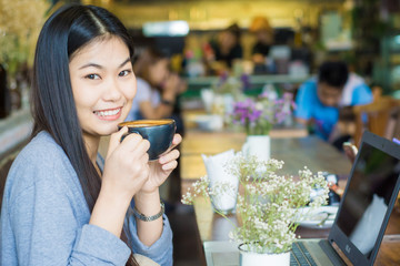 Beautiful asian woman using laptop inside coffee shop