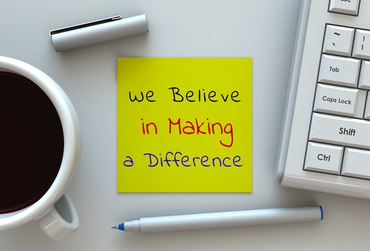 We Believe in Making a Difference, message on note paper, computer and coffee on table