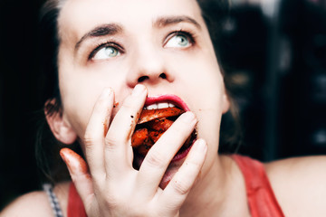 Woman binge eating french fries, mouth full of food