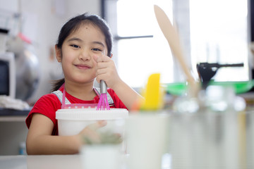 Little Asian cute chef cooking a bakery in kitchen