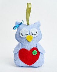 Doll owl with his hands on white background