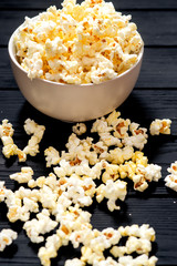 cheese popcorn in the bowl with a glass of cola or beer and potato chips on the wooden background