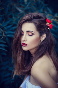 beautiful young brunette woman in a Park at sunset with flower wreath