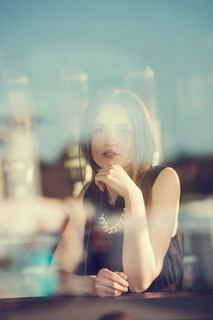 Fototapeta Caucasian girl city portrait. Woman smiling outside in evening light on street.  Young cheerful fashion woman
