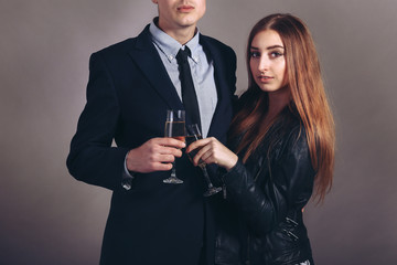 Portrait young couple with glass of champagne, wear evening dress and suit, glamour vogue style, sensual looking at camera, sitting indoors