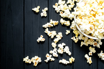 cheese popcorn in the bowl with a glass of cola or beer and potato chips on the wooden background