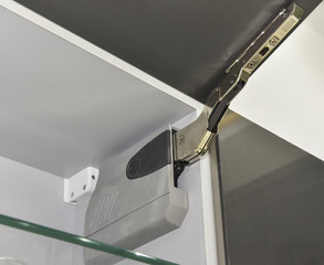 Closeup detail of a hinge on kitchen cupboard