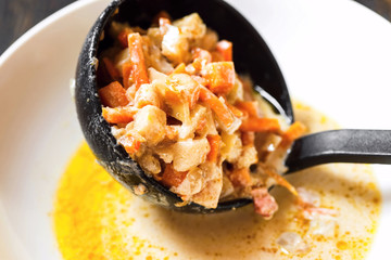 Diced vegetable on black scoop in white plate