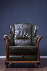 Green leather armchair in front of the wall