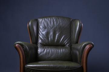 Green leather armchair in front of the wall