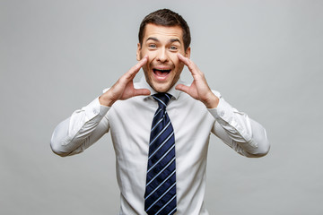 Handsome stylish businessman on grey background