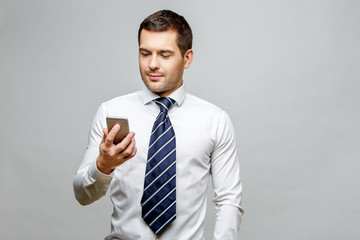 Handsome stylish businessman on grey background