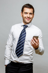 Handsome stylish businessman on grey background
