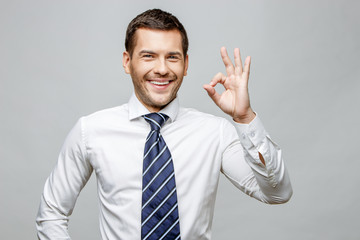 Handsome stylish businessman on grey background