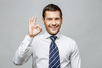 Handsome stylish businessman on grey background