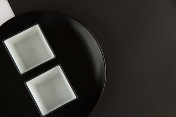 A number of flat plates and cups on black and white background