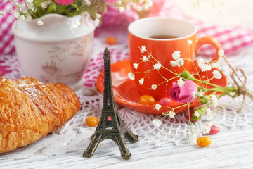 cup of coffee and croissant with the small Eiffel Tower