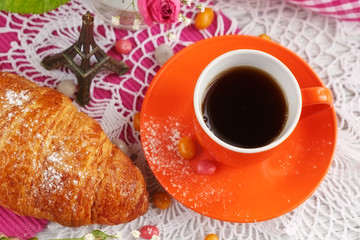 cup of coffee and croissant with the small Eiffel Tower