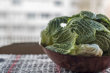 Obraz premium Savoy Cabbage Leaves in a Wooden Bowl