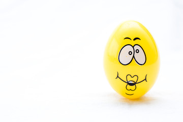 Fototapeta premium yellow egg with a face on a white background 