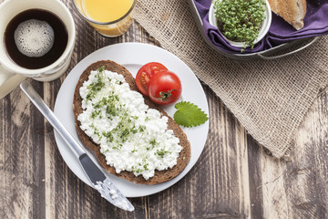 healthy spring summer low fat breakfast with orange juice,coffee,bread,cottage cheese, cress and tomatos