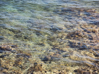 Paisaje de mar con agua transparente y fondo marino de piedras rugosas, España 2016