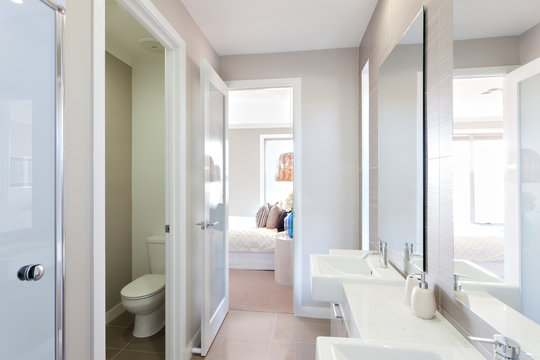 View of a modern bathroom with toilet and way to the bedroom