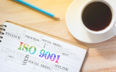 Concept ISO 9001 message on book. A pencil and a glass coffee table.Vintage tone.