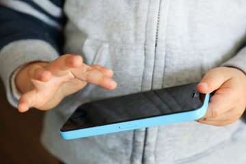 スマートフォンで遊ぶ子供