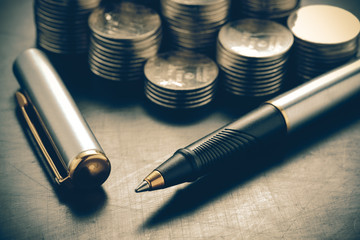 money concept coins and pen with filter effect retro vintage sty