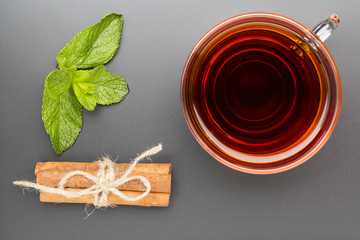 Glass cup of tea with mint and cinnamon stick