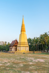 Fototapeta premium Golden pagoda with Old Buddhism church (Ubosot) in public temple, Thailand
