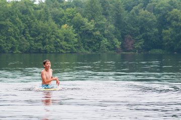 boy swimming in a lake in the summertime