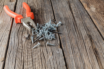 Old pliers on brown wooden background in rustic style.