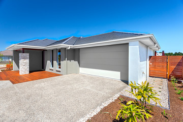 Fototapeta premium Modern house with a garage and backyard area and blue sky