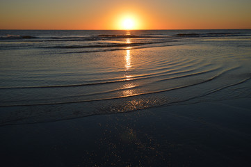 Sunrise over the Atlantic Ocean reflecting on the incoming tide in North Florida, USA