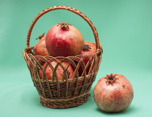 basket with Pomegranate on green background