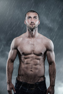 Athletischer Mann  bei Abkühlung im Regen 
