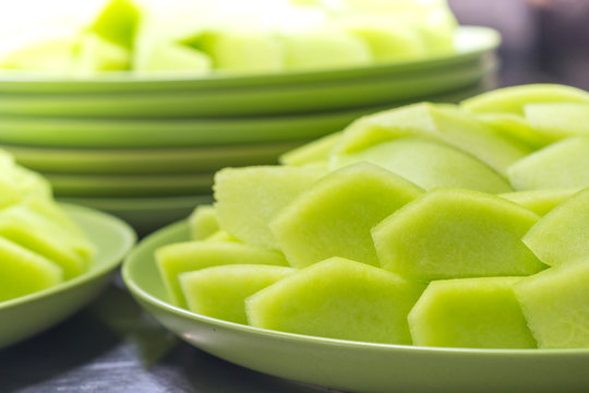 many pieces light green cantaloupe on green plate
