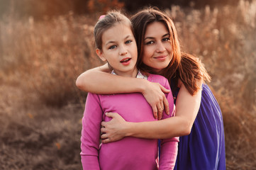 Fototapeta premium lifestyle capture of happy mother and preteen daughter having fun outdoor. Loving family spending time together on the walk. Cozy weekend.