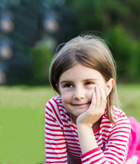 a beautiful young girl lays in a field