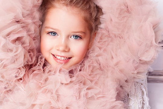 Happy smiling girl in pink lace. Close up portrait 