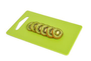 Kiwi on a green cutting board isolated on white