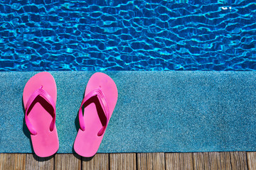 Naklejka premium Slippers by a swimming pool