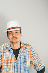 a young man with a hat on a gray background