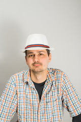 a young man with a hat on a gray background