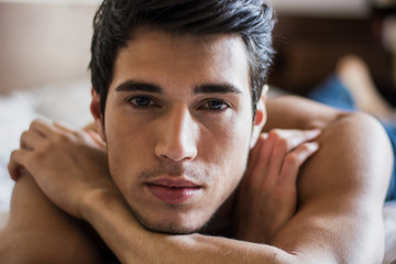 Obraz premium Shirtless sexy male model lying alone on his bed