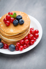 Stack of pancakes with blueberry and fresh berry.