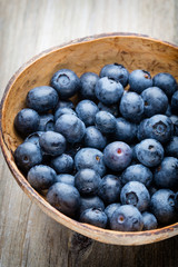 Blueberries in a bowl on a wooden table.