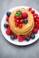 Stack of pancakes with blueberry and fresh berry.